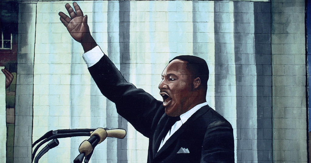 Painted mural of Martin Luther King Jr. speaking with hand raised