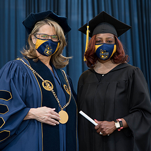Image of La Salle University President Colleen Hanycz presenting a diploma to a graduating student at the University's commencement at Lincoln Financial Field in Philadelphia, May 15, 2021.