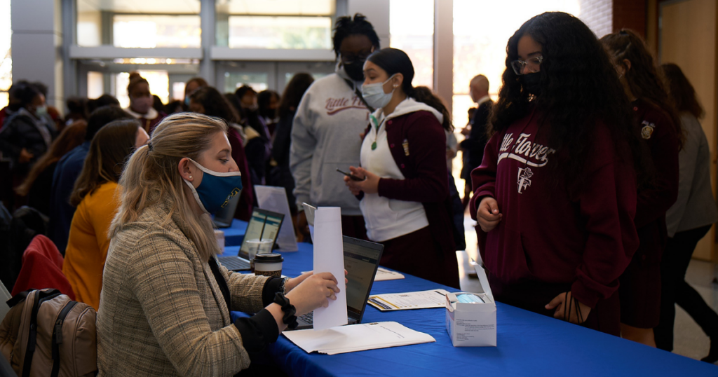 Image of an Admissions Counselor checking in a student.