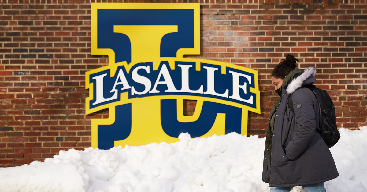 Image of a La Salle University student walking on campus after a snowstorm.