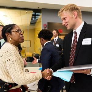 business school student shaking hands with company representative