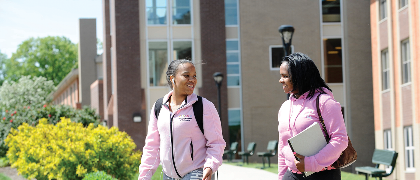 Image of two female students outside of the residence hall
