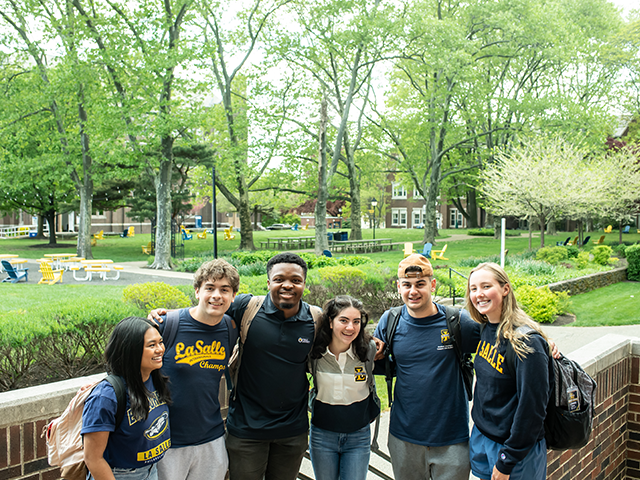 A group of students posing for a photo in front of the Hansen Quad.