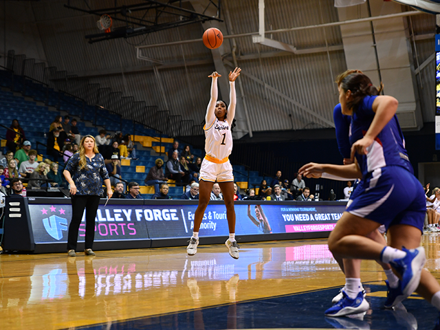 A women's basketball player about to shoot the ball.