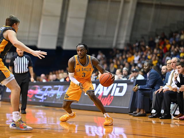 Image of a men's basketball player dribbling a ball.
