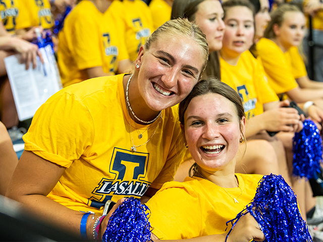 Image of two female students holding pom poms