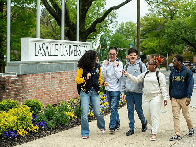 Image of five students walking in front of the La Salle University sign.