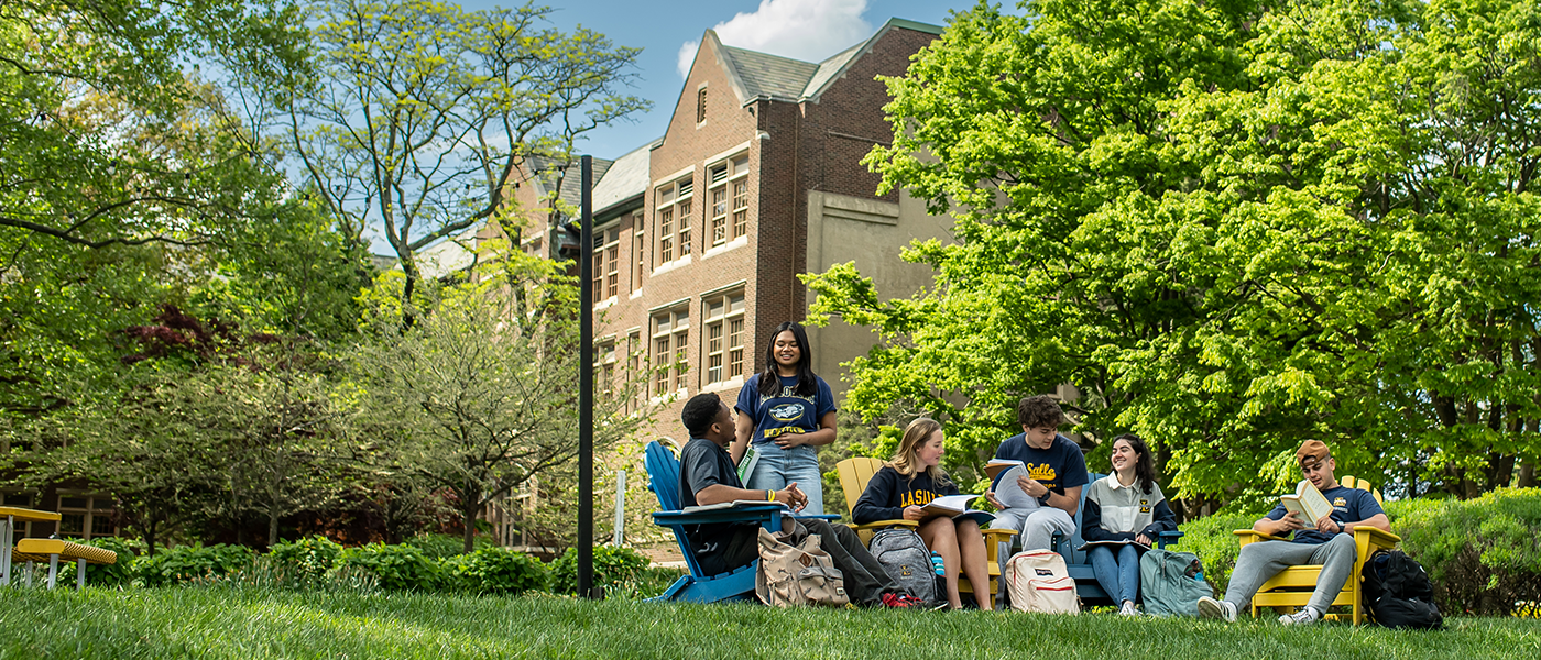 Image of students sitting on the Hansen Quad and enjoying warmer weather.