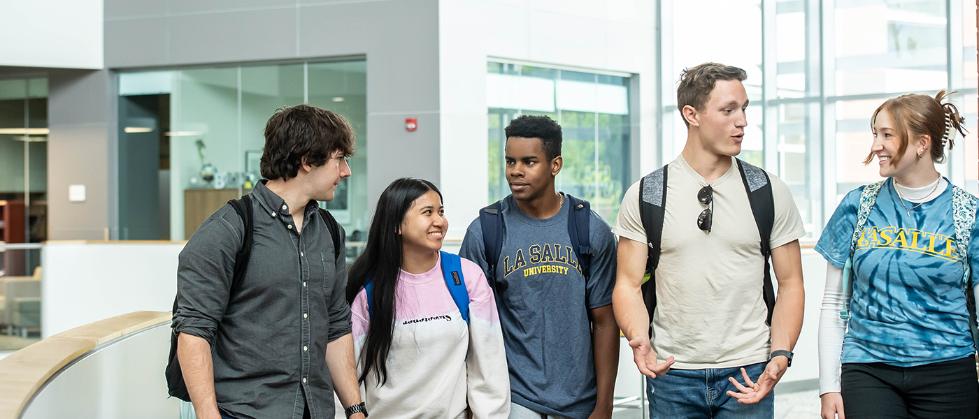 Image of five students walking around Founders' Hall.