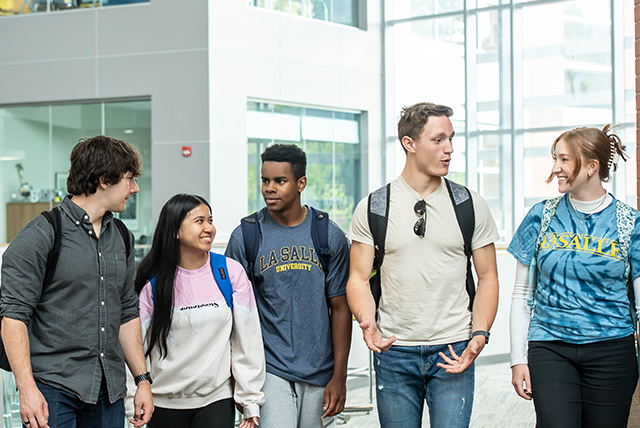 Image of five students walking around campus.