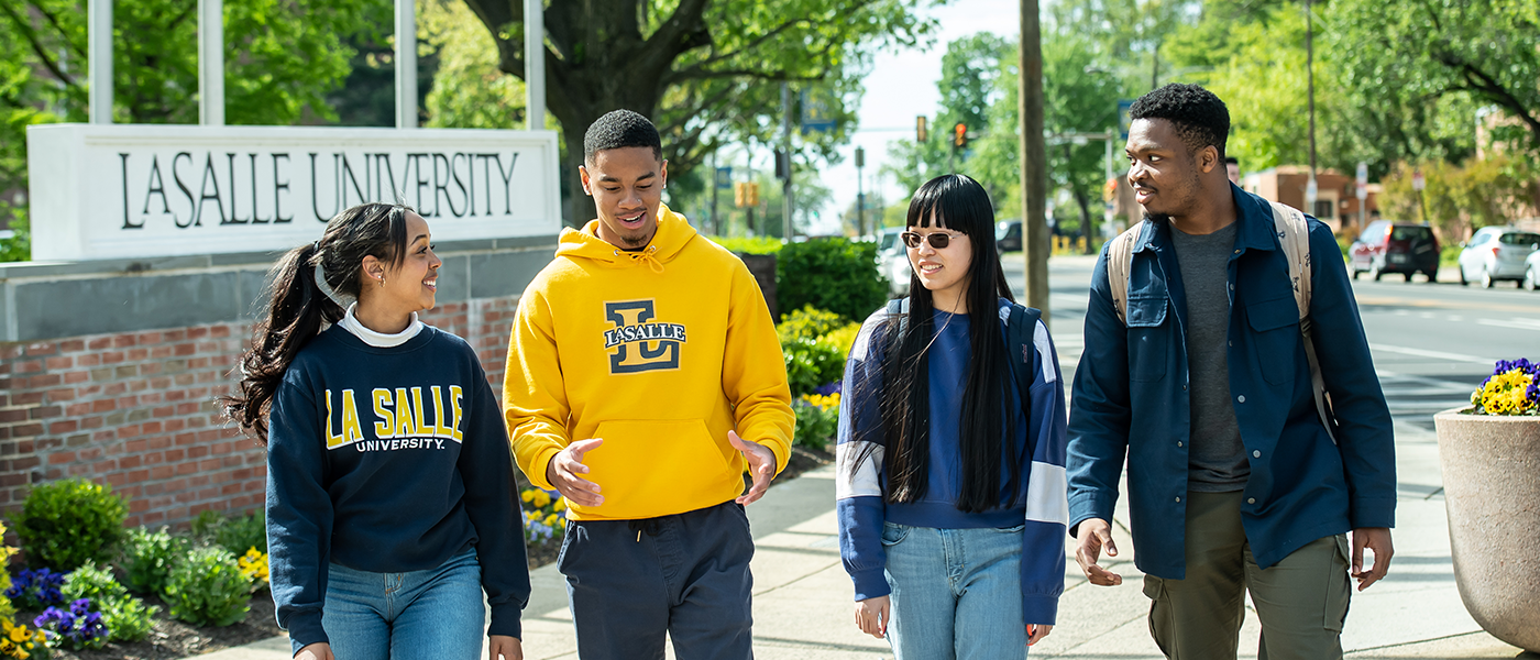 Image of four students walking around La Salle's campus.