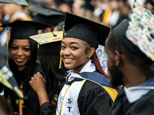 Image of a female student smiling at the camera during Commencement.