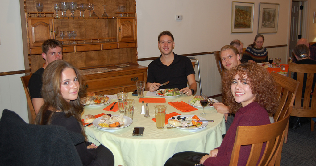 Chanel Muir (left rear), New Zealander, Explorer cross country runner, and Assistant Chef, and other guests.