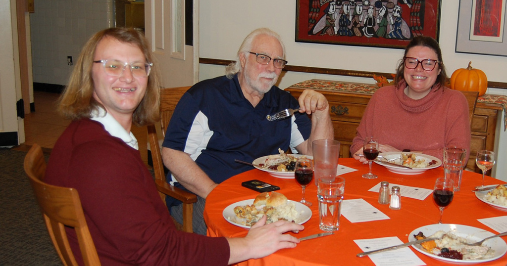 A Brother of the Community is flanked by two colleagues: the Director of the newly re-formed Pep Band (his first appearance) and the Director of Undergraduate Admissions (her 11th!)