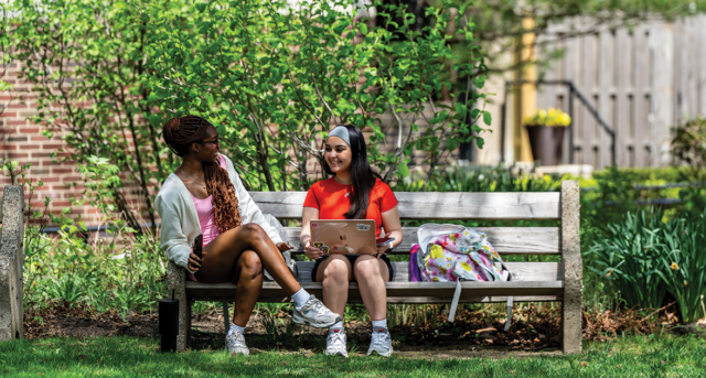 Image of two students sitting on a bench on the Hansen Quad