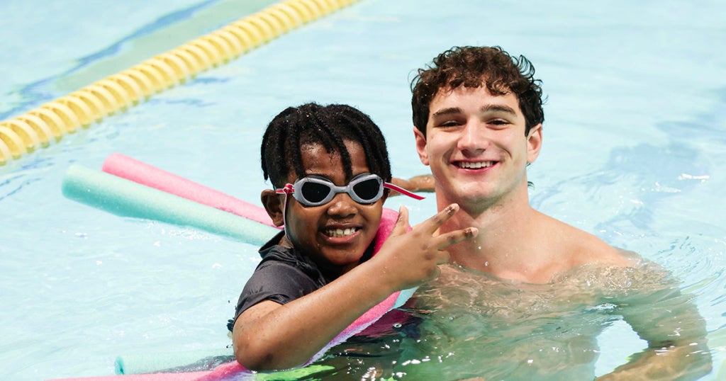 James Logan Elementary School second graders with Explorer student-athletes during the Learn to Swim Pilot Program.