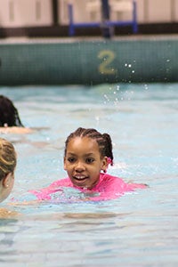 James Logan Elementary School second graders with Explorer student-athletes during the Learn to Swim Pilot Program.