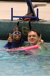 James Logan Elementary School second graders with Explorer student-athletes during the Learn to Swim Pilot Program.