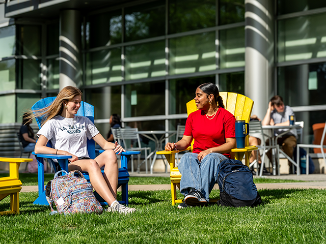 2 students sitting outside and talking