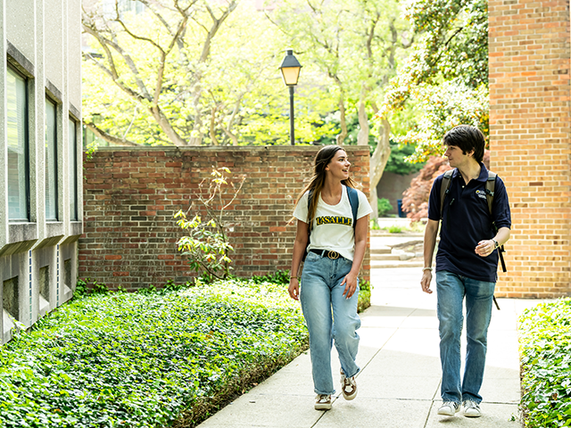 2 students walking down a sidewalk