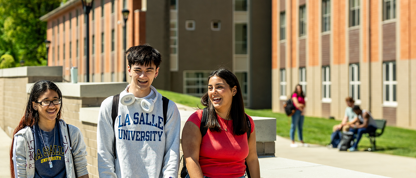 3 students walking outside of st basil