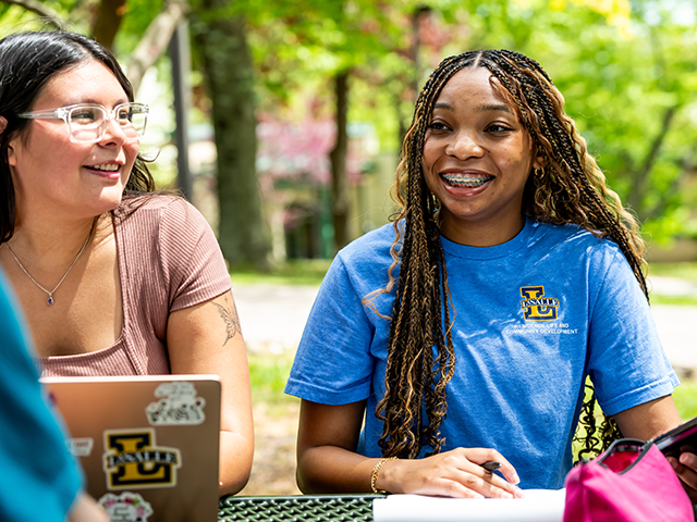 Image of students sitting at a table on the Quad