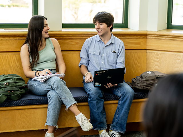 Image of two students working in the library