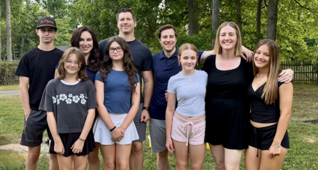 Photo of two alumni with their families.