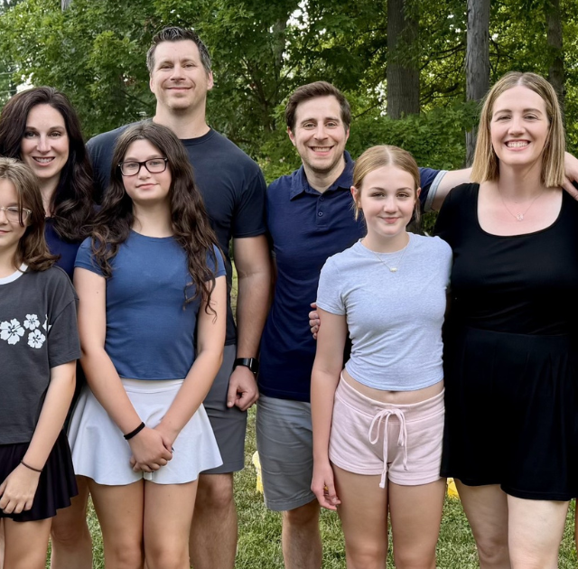 Photo of two alumni with their families.