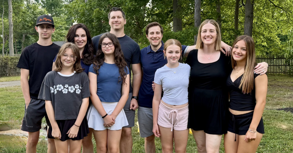 Photo of two alumni with their families.