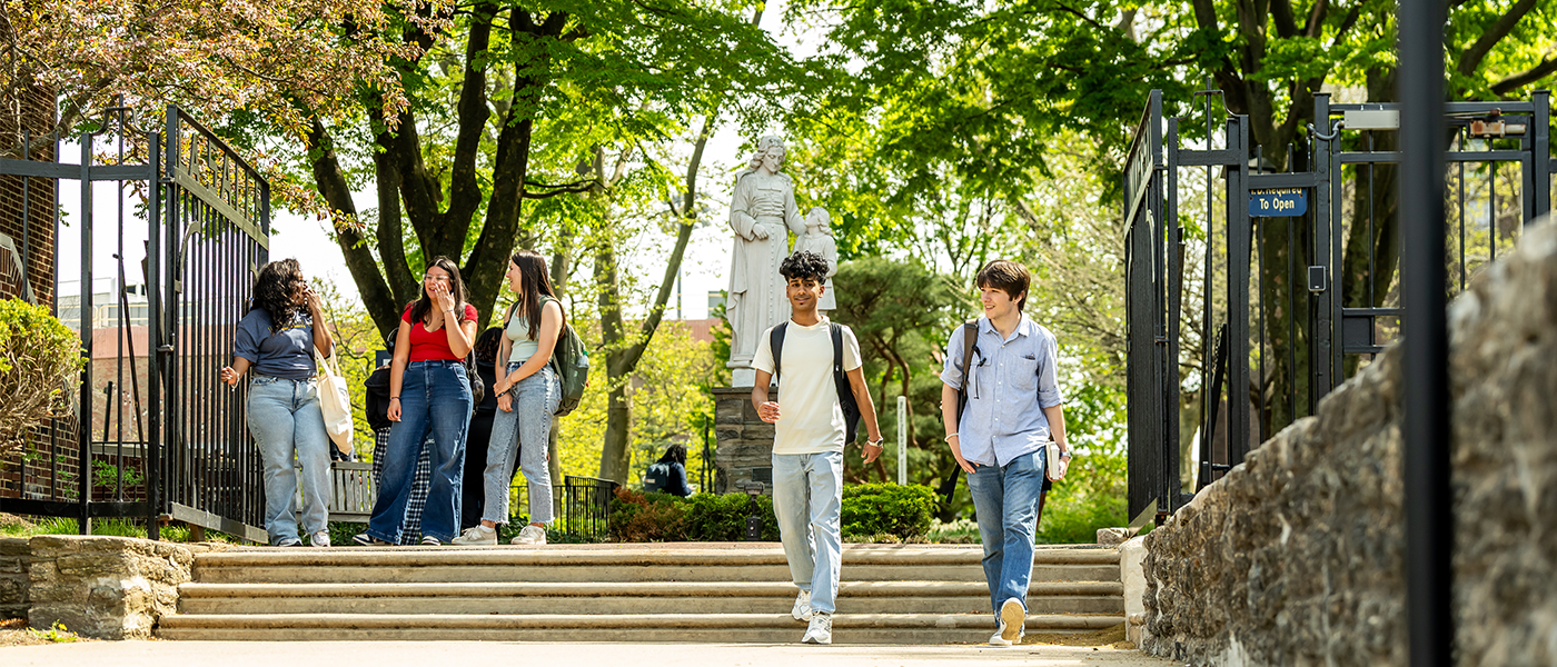 Image of students walking out of the campus gate on Olney Ave