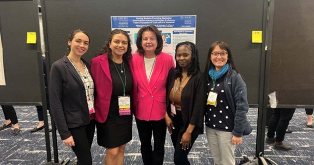 Beth Ann Swan (center) with La Salle students and faculty at a poster presentation.