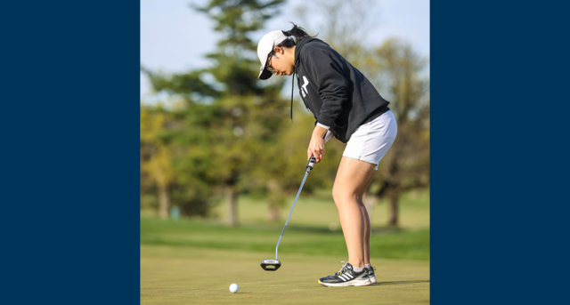 A member of the women's golf team putting
