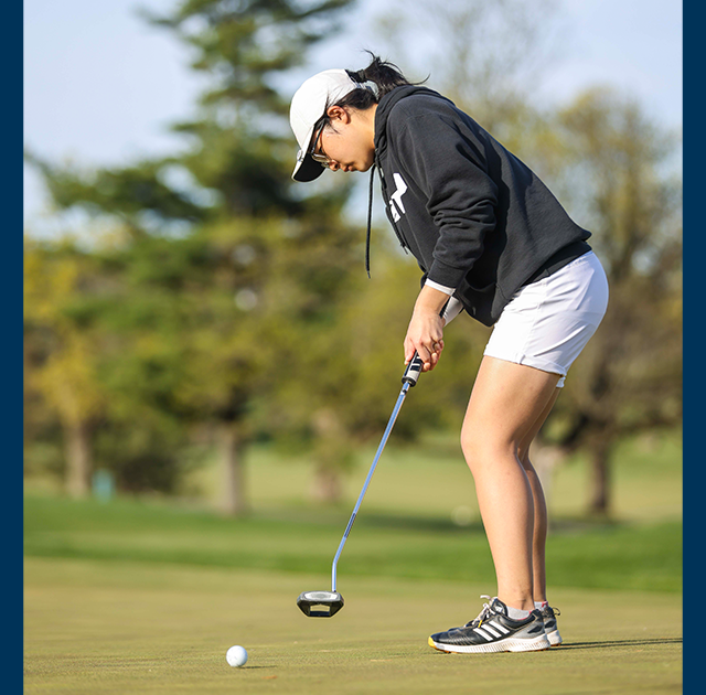 A member of the women's golf team putting