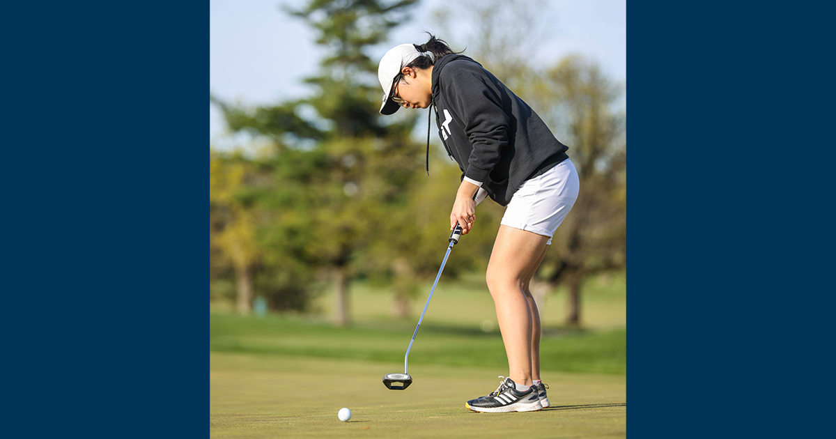 A member of the women's golf team putting