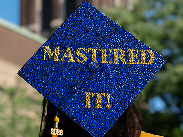 Bedazzled blue and gold grad cap that says mastered it!