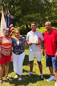 Dezlen Long, '27, with his family after being awarded the Greenspan Scholarship.