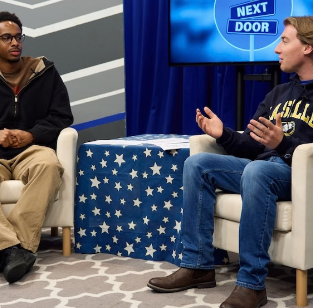 Two students sitting in two chairs talking