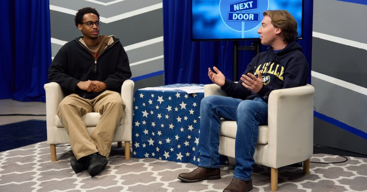 Two students sitting in two chairs talking