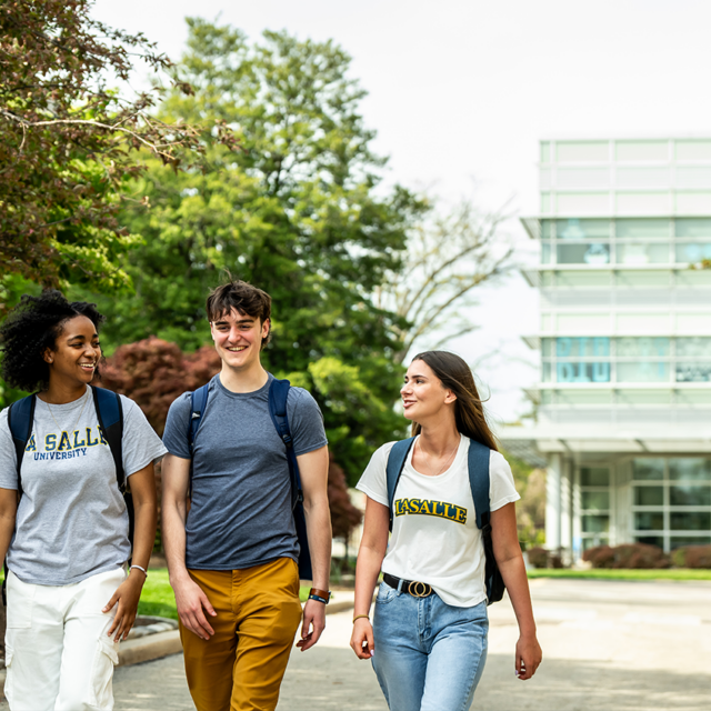 Three students walking across campus